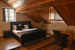 a bedroom with a bed and a desk in it at Beautiful home opposite Speke Resort Munyonyo near Lake Victoria in Kampala