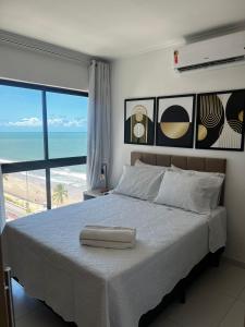 Un dormitorio con una cama con vistas a la playa. en Beira-Mar Boa Viagem - Ivone Asfora by Bnb Flex, en Recife