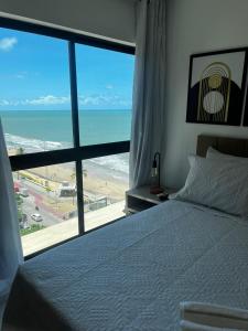 1 dormitorio con cama y vistas al océano en Beira-Mar Boa Viagem - Ivone Asfora by Bnb Flex en Recife