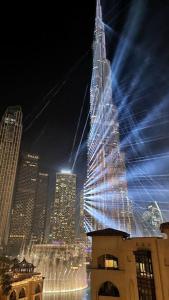 un edificio alto con luces encendidas en una ciudad en ULTIMATE DXB DOWNTOWN PENTHOUSE, en Dubái