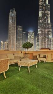 a patio with chairs and tables and a city skyline at ULTIMATE DXB DOWNTOWN PENTHOUSE in Dubai