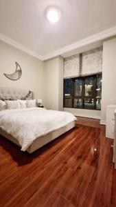 a bedroom with a large white bed and wooden floors at ULTIMATE DXB DOWNTOWN PENTHOUSE in Dubai