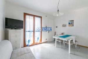 Pokój ze stołem, telewizorem i łóżkiem w obiekcie Residence Al Porticciolo w Cavallino-Treporti