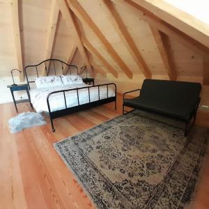 a bedroom with two beds and a rug in a attic at Chalet Ridente con Patio al Gufo in Ovaro