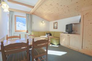 sala de estar con mesa, sofá y TV en Ausserwieserhof, en Neustift im Stubaital