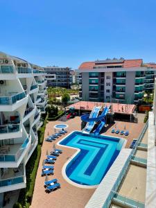 een resort met een zwembad en stoelen en gebouwen bij SA Apartments! Crystal Family Suites in Alanya