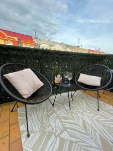 dwa krzesła i stół na patio w obiekcie Tara Apartment w Karlowych Warach