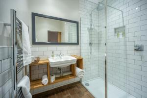 uma casa de banho branca com um lavatório e um chuveiro em Saplinbrae Hotel and Lodges em Mintlaw