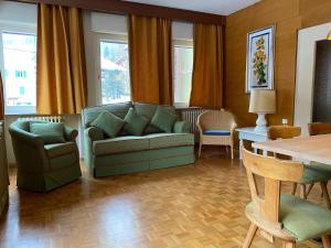 sala de estar con sofá, sillas y mesa en Villa Ginestra - 1, en Moena