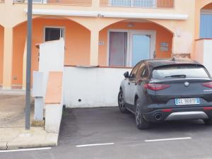 a car parked in a parking lot in front of a building at Trinità d'Agultu-Isola Rossa, località La Frisaia, entire apartment, sleeps 6 in Trinità d'Agultu e Vignola