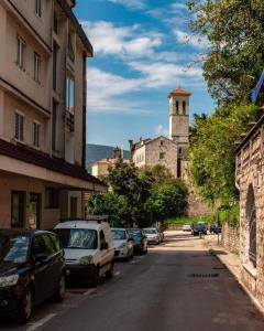 una calle con coches estacionados en el lateral de un edificio en Jasna Herceg Novi en Herceg-Novi