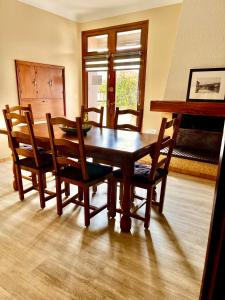 uma mesa de jantar em madeira com cadeiras e um piano em Private Rooms & Bath em Tonneins