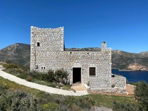 un antiguo edificio de piedra al lado de una colina en Taenarioum antico en Páliros