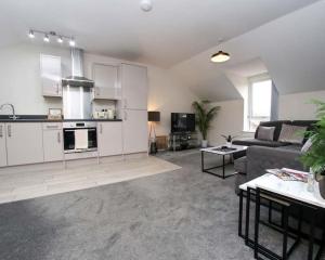 ein Wohnzimmer mit einem Sofa und einer Küche in der Unterkunft Luxe Living Guest House-Sleeps 6-Private Parking-Free WIFI-Beach-City in Swansea