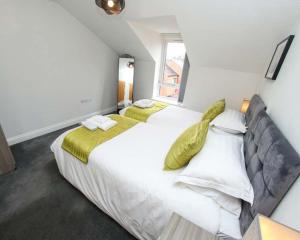 1 dormitorio con 2 camas y ventana en Luxe Living Guest House-Sleeps 6-Private Parking-Free WIFI-Beach-City en Swansea