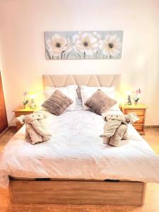 a bedroom with a bed with two stuffed animals on it at Sea Breeze Apartament in Benicarló