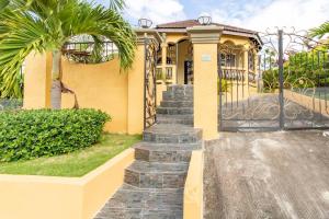 una casa con una puerta y escaleras delante de ella en Impeccable 2-Bed House in Montego Bay, en Montego Bay