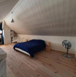 a bedroom with a blue bed and a wooden floor at La maison du Lac in Doussard