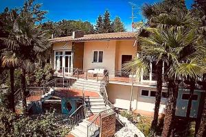 Fara Novarese的住宿－Spacious new 2 bdr walk-out apartment，前面有棕榈树的房子