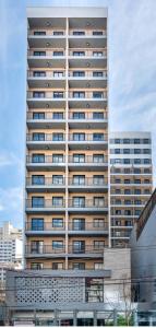 a tall building with many windows in a city at Liberdade SP a 250m do metrô in Sao Paulo