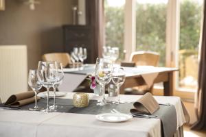 a table with wine glasses on top of it at Hotel De Maretak in Dilsen-Stokkem