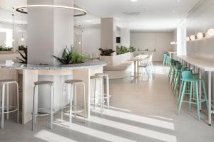 a lobby with a bar and stools at B&B HOTEL Elche in Elche