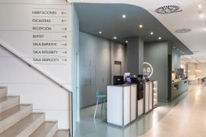 a lobby with a staircase and a sign with the name of a pharmacy at B&B HOTEL Elche in Elche