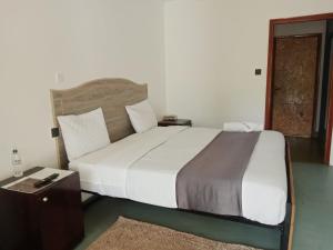 een slaapkamer met een groot wit bed en een tafel bij Riverside Villas Nanyuki in Nanyuki
