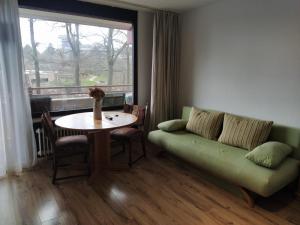 sala de estar con sofá, mesa y ventana en B211 Gemütliches Appartement für Urlauber und Berufsreisende en Lahnstein