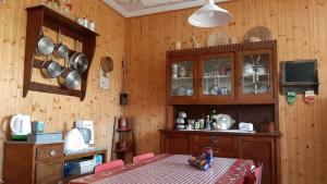 Casa riservata sulle colline di Parma oasi di pace في Neviano degli Arduini: غرفة طعام مع طاولة ومطبخ مع جدران خشبية