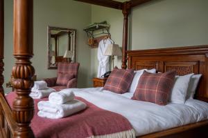 Saplinbrae Hotel and Lodges في Mintlaw: غرفة نوم عليها سرير وفوط