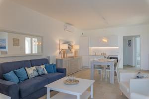 a living room with a blue couch and a table at Villa Arca by RivedelSalento in Otranto