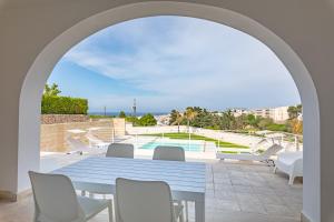 une arche avec une table et des chaises sur la terrasse dans l'établissement Villa Arca by RivedelSalento, à Otrante