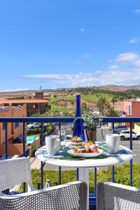 a table with a plate of food on a balcony at Bahia Meloneras MJV96 by VillaGranCanaria in Meloneras