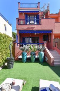 a house with three blue vases on the lawn at Bahia Meloneras MJV96 by VillaGranCanaria in Meloneras