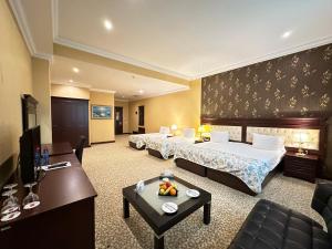 巴库Modern Hotel的酒店客房,设有两张床和一张沙发 更多37张照片