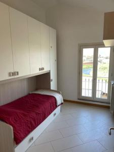ein Schlafzimmer mit einem roten Bett und einem Fenster in der Unterkunft Charming apartment in Tuscany in San Piero in Campo