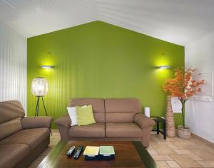 a living room with a couch and a green wall at Herdade do Kuanza in Zambujeira do Mar