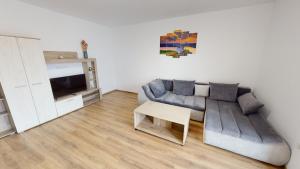 a living room with a couch and a table at Harmony Apartment VRT in Şelimbăr