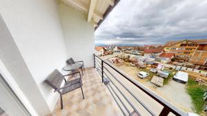 a balcony with a chair and a view of a city at Harmony Apartment VRT in Şelimbăr