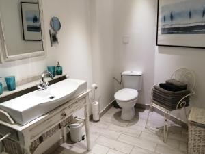 a white bathroom with a sink and a toilet at Limoux Vacances in Limoux