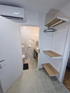 a bathroom with a staircase and a toilet and a sink at B-TIM Apartment in Velika Gorica