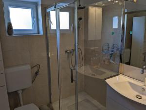 ein Bad mit einer Dusche und einem Waschbecken in der Unterkunft Appartement Blue Lagune 4 Sterne in Prizna