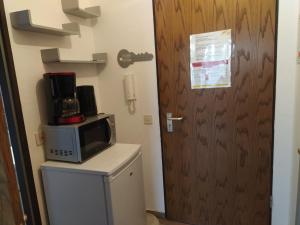 a microwave sitting on top of a refrigerator next to a door at App B210 gemütlich und ruhig in Lahnstein +10 photos