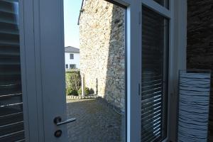 a door with a view of a stone wall at Weingut Heinen in Longuich