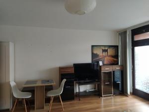 a living room with a tv and a table and chairs at App B210 gemütlich und ruhig in Lahnstein