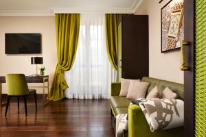a living room with a green couch and yellow curtains at Hotel L'Orologio Roma - WTB Hotels in Rome