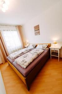 een bed in een kamer met een raam en een nachtkastje bij Das Harznest, WLAN in Bad Sachsa