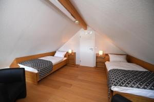 a attic room with two beds and a mirror at Weingut Heinen in Longuich
