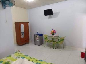 um quarto com uma mesa e uma televisão e uma mesa e cadeiras em Hoài Oanh homestay em Mui Ne